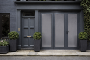 Façade moderne avec porte d’entrée et baies vitrées aluminium gris anthracite, style épuré.