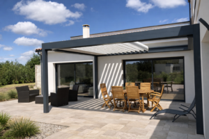Pergola bioclimatique aluminium anthracite installée sur terrasse en carrelage effet pierre