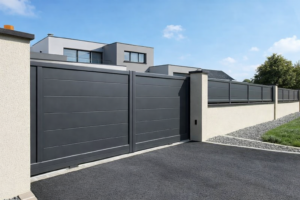 Portail aluminium plein battant RAL 7016 satiné devant une maison contemporaine avec clôture assortie.